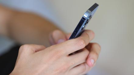 Ein Jugendlicher hält ein Smartphone in den Händen.