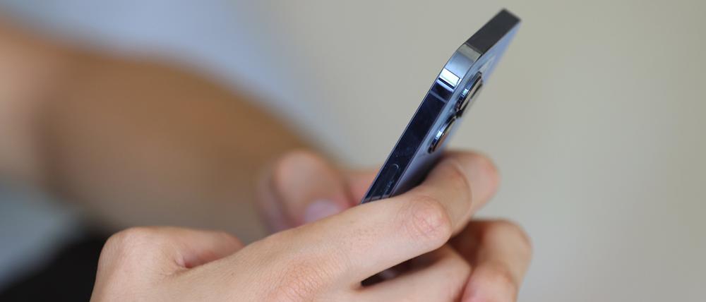 Ein Jugendlicher hält ein Smartphone in den Händen.