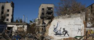 An einem kriegszerstörten Haus ist ein Graffiti zu sehen.