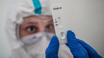 Ein medizinischer Mitarbeiter zeigt einen Corona-Test