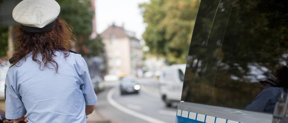  Polizistin neben ihrem Streifenwagen.