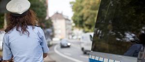 Polizistin neben ihrem Streifenwagen.