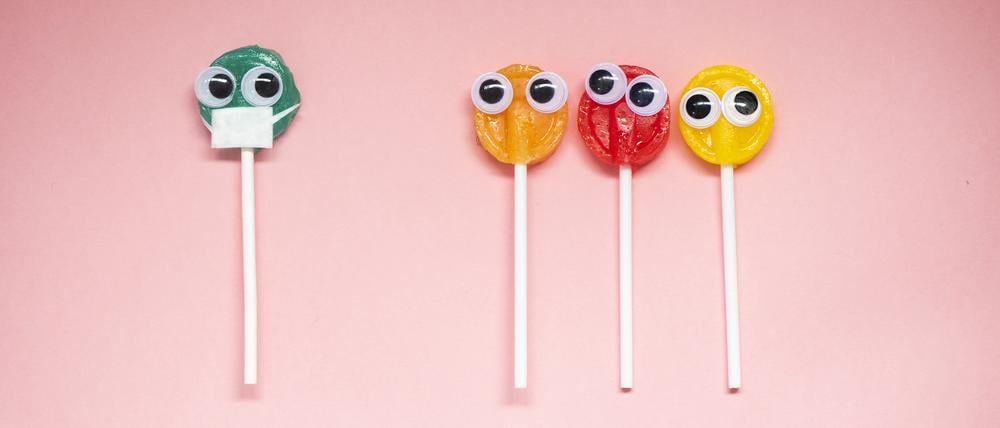 Lollipop with Cartoon Eyes on Pink Colored Background, social distancing and coronavirus concept.