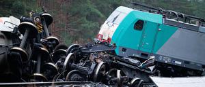 Ein entgleister Triebwagen vom aufgefahrenen Güterzug und mehrere Radachsen liegen verstreut auf und abseits der Schiene. 