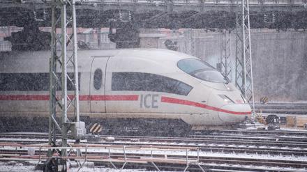 Ein ICE 3 der Deutschen Bahn fährt bei dichtem Schneefall aus dem Hauptbahnhof.