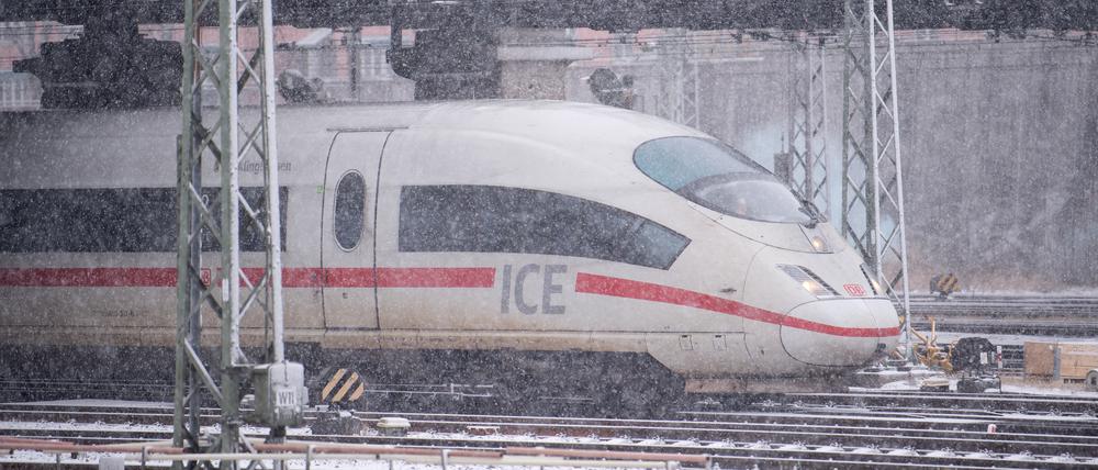 Ein ICE 3 der Deutschen Bahn fährt bei dichtem Schneefall aus dem Hauptbahnhof.
