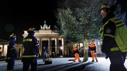 Mitarbeiter des THW stellen einen Weihnachtsbaum vor dem Brandenburger Tor auf. 
