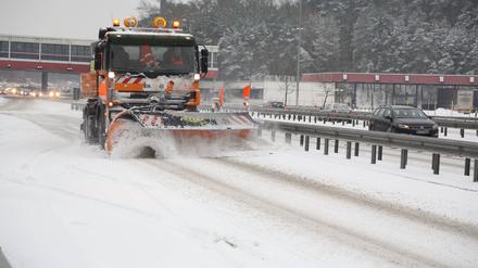 Auf der Autobahn A115 wird der Schnee von der Fahrbahn geräumt. 