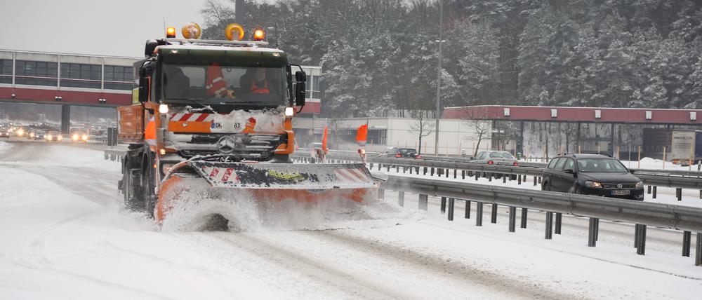 Auf der Autobahn A115 wird der Schnee von der Fahrbahn geräumt. 