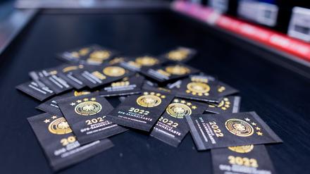 Sammelkarten zum offiziellen DFB-Sammelalbum zur Fußball-Weltmeisterschaft in Katar liegen im Kassenbereich eines Rewe Marktes. 