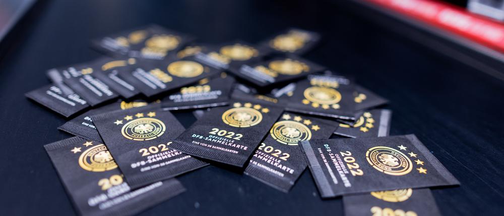 Sammelkarten zum offiziellen DFB-Sammelalbum zur Fußball-Weltmeisterschaft in Katar liegen im Kassenbereich eines Rewe Marktes. 
