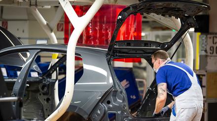 Ein VW-Mitarbeiter arbeitet an der Produktion eines Autos. 