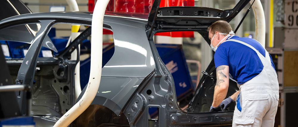 Ein VW-Mitarbeiter arbeitet an der Produktion eines Autos.