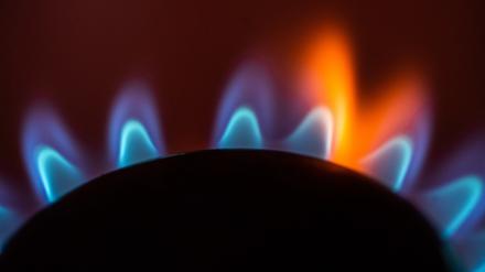 Die Flamme eines Gasherdes brennt in einer Küche.