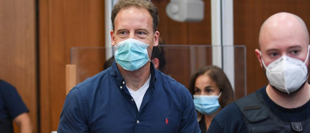 Der Unternehmer Alexander Falk (M) kommt in Begleitung von Justizbeamten zur Urteilsverkündung in den Gerichtssaal des Landgerichts.
