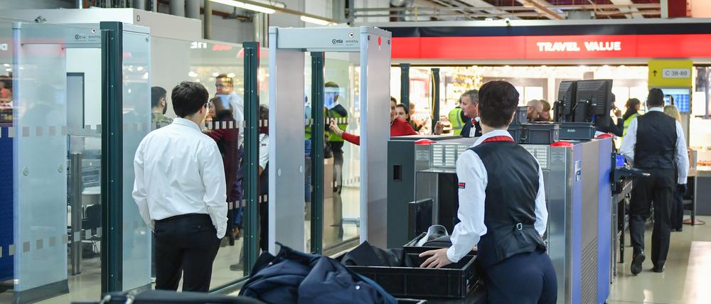 Passagiere und ihr Handgepäck werden bei einer Sicherheitskontrolle im Flughafen Tegel kontrolliert. 