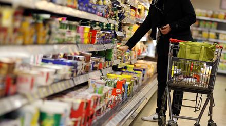 Ein Kunde steht vor einem Supermarktregal.