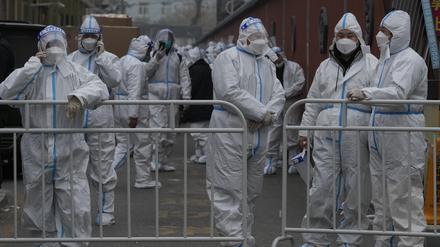 Arbeiter in Schutzanzügen bereiten sich im Rahmen der Corona-Kontrollen auf ihren Einsatz in einem abgesperrten Viertel vor.