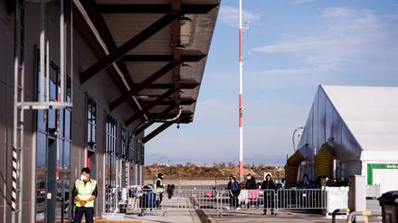 Mitarbeiter der Security stehen vor einem Unterkunftszelt für Geflüchtete im Ukraine-Ankunftszentrum Tegel, Terminal C, im ehemaligen Flughafen Tegel.