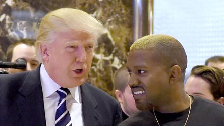 Auf diesem Dateifoto vom 13. Dezember 2016 kommen der Sänger Kanye West und Ex-Präsident Donald Trump nach ihrem Treffen im Trump Tower in New York zum Gespräch mit der Presse. (Archivbild)