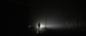 Eine Frau spaziert durch das dunkle Stadtzentrum von Kiew.