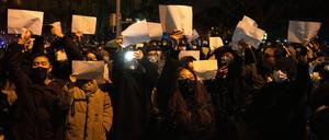 Demonstrierende in der chinesischen Hauptstadt Peking halten leere Papiere hoch.