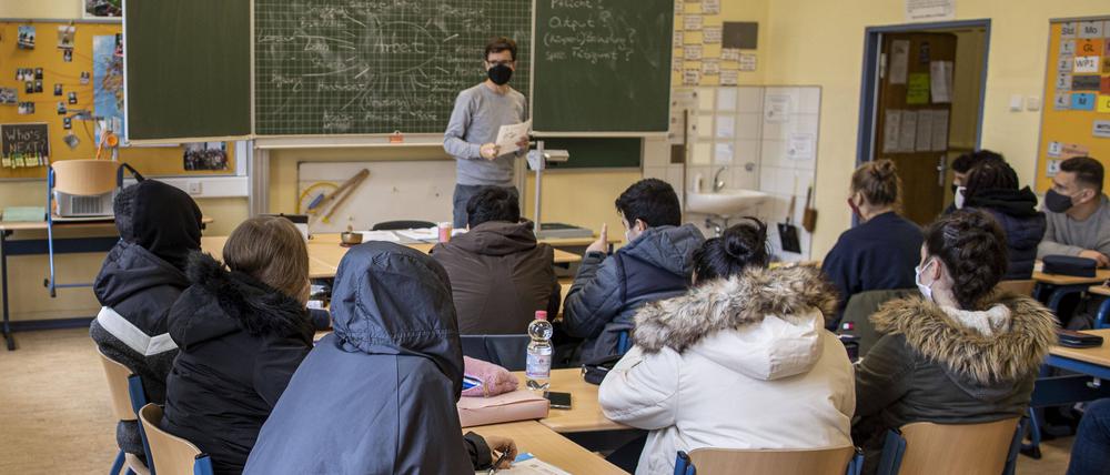 Schüler sitzen in ihren dicken Winterjacken in ihrem Klassenraum (Symbolbild).