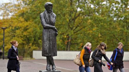 Vier Frauen laufen am 16.10.2012 an einer Statue des Schriftstellers Heinrich Heine auf dem Gelände der Heinrich-Heine-Universität in Düsseldorf (Nordrhein-Westfalen) vorbei. Ein Gutachter der Universität wirft Bundesbildungsministerin Schavan (CDU) Medienberichten zufolge vor, in ihrer vor mehr als 30 Jahre erstellten Doktorarbeit bewusst getäuscht zu haben. 