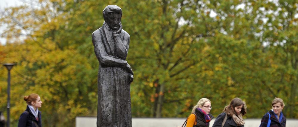 Vier Frauen laufen am 16.10.2012 an einer Statue des Schriftstellers Heinrich Heine auf dem Gelände der Heinrich-Heine-Universität in Düsseldorf (Nordrhein-Westfalen) vorbei. Ein Gutachter der Universität wirft Bundesbildungsministerin Schavan (CDU) Medienberichten zufolge vor, in ihrer vor mehr als 30 Jahre erstellten Doktorarbeit bewusst getäuscht zu haben.