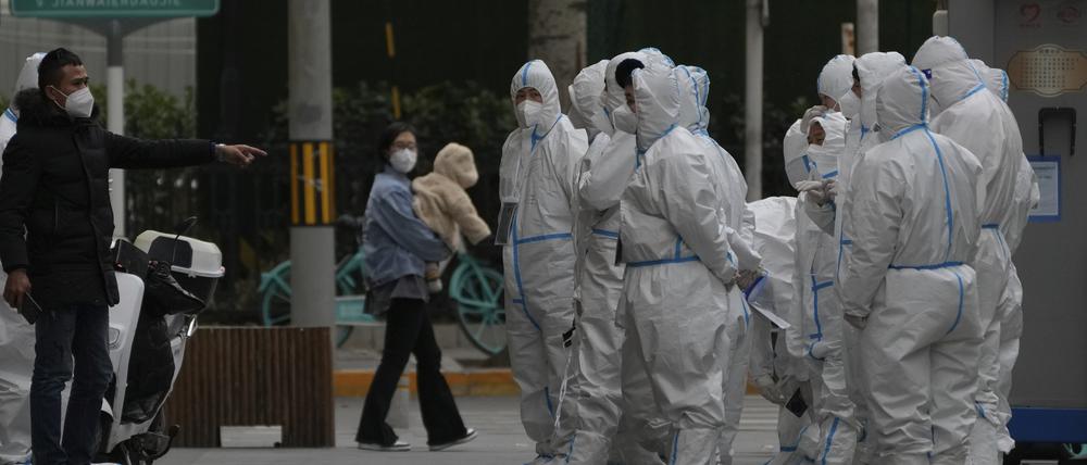 Arbeiter in Schutzkleidung versammeln sich zu ihrem Dienst in Peking.