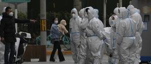 Arbeiter in Schutzkleidung versammeln sich zu ihrem Dienst in Peking.