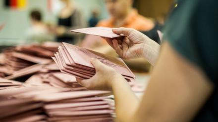 Eine Wahlhelferin sortiert Briefwahlstimmen in der Mensa einer Schule in Berlin. 