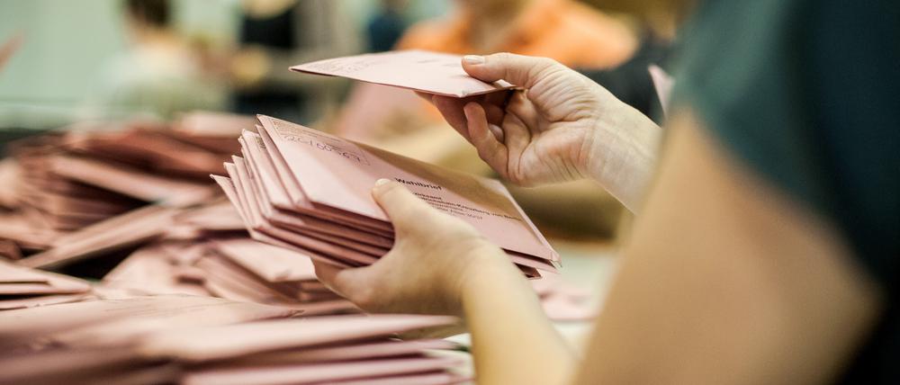 Eine Wahlhelferin sortiert am 25.05.2014 Briefwahlstimmen in der Mensa einer Schule in Berlin.