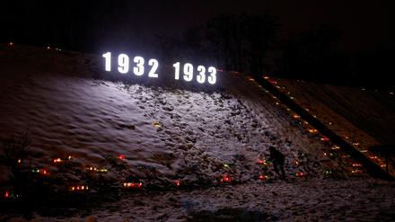 A man places a candle at a compound of a monument to Holodomor victims during a commemoration ceremony of the famine of 1932-33, in which millions died of hunger, in Kyiv, Ukraine November 26, 2022. REUTERS/Valentyn Ogirenko REFILE - CORRECTING YEAR