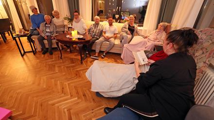 Zusammensein: Bewohner:innen und ihre Angehörigen bei einer Vorlesestunde. 