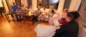 Zusammensein: Bewohner:innen und ihre Angehörigen bei einer Vorlesestunde. 