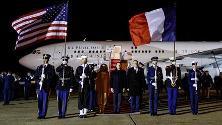 French President Emmanuel Macron (C) and his wife Brigitte Macron (C-L) arrive at Joint Base Andrews in Maryland on November 29, 2022. - Macron is in Washington to discuss a slew of issues with US counterpart Joe Biden, ranging from aligning policy on Russia's invasion of Ukraine to easing trade spats. (Photo by Ludovic MARIN / AFP)
