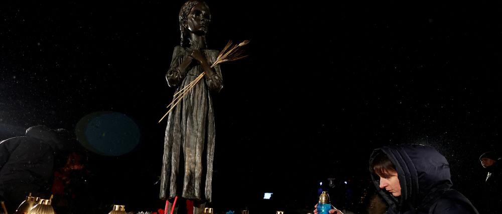 A woman places a candle at a monument to Holodomor victims during a commemoration ceremony of the famine of 1932-33, in which millions died of hunger, amid Russia's attack on Ukraine, in Kyiv, Ukraine November 26, 2022. REUTERS/Valentyn Ogirenko REFILE - CORRECTING YEAR