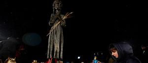 A woman places a candle at a monument to Holodomor victims during a commemoration ceremony of the famine of 1932-33, in which millions died of hunger, amid Russia's attack on Ukraine, in Kyiv, Ukraine November 26, 2022. REUTERS/Valentyn Ogirenko REFILE - CORRECTING YEAR