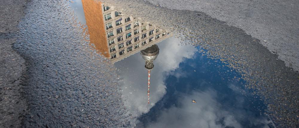 Der Berliner Fernsehturm spiegelt sich in einer Pfütze.