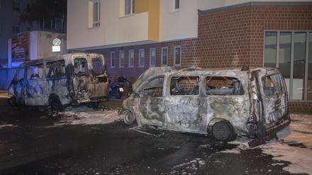 Zwei ausgebrannte Polizeifahrzeuge stehen an der Wache der Polizeistation 55.