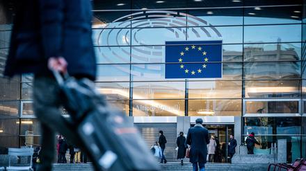 Passanten gehen vor dem Sitz des Europäischen Parlaments entlang. 