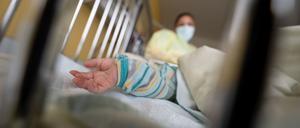 Ein Baby liegt auf einer Kinderstation im Krankenbett. 