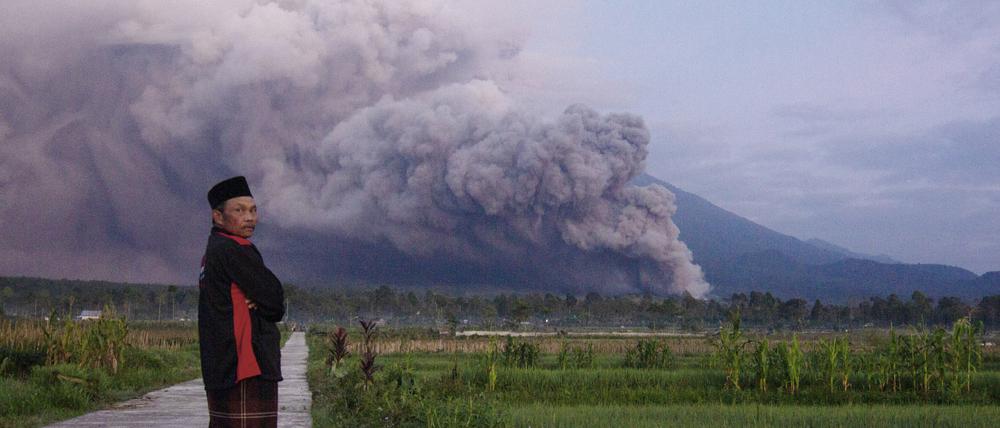 Ein Mann in Lumajang, Indonesien beobachtet den Ausbruch des Vulkans Semeru.
