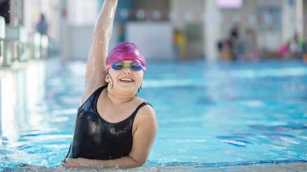 young and successful swimmers pose in swimming pool