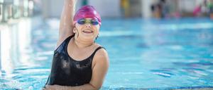 young and successful swimmers pose in swimming pool