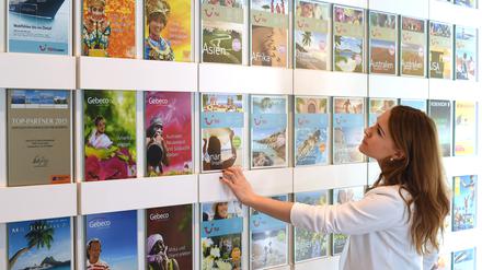 Eine Frau blickt in einem Reisebüro auf Kataloge. ie Osterreisewelle hat im April 2019 die Verbraucherpreise in Deutschland mit nach oben getrieben. Unter anderem wegen stark verteuerter Pauschalreisen. (Zu dpa «Verbraucherpreise im April 2 Prozent über Vorjahr») +++ dpa-Bildfunk +++