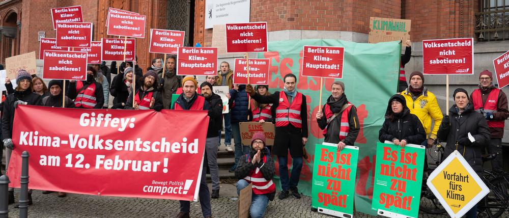 Mit einem Banner und Sprechchören stehen Aktivisten und Unterstützer von Campact vor dem Roten Rathaus.