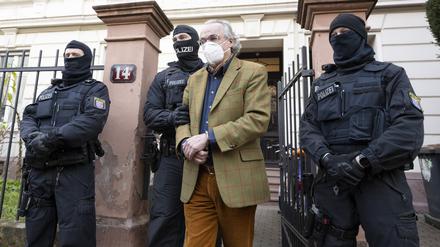 Bei einer Razzia gegen sogenannte „Reichsbürger“ führen vermummte Polizisten, nach der Durchsuchung eines Hauses Heinrich XIII. Prinz Reuß (2.v.r.) zu einem Polizeifahrzeug.