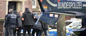 Eine Person (2. v. r.) wird von Polizisten aus einem Hubschrauber gebracht.